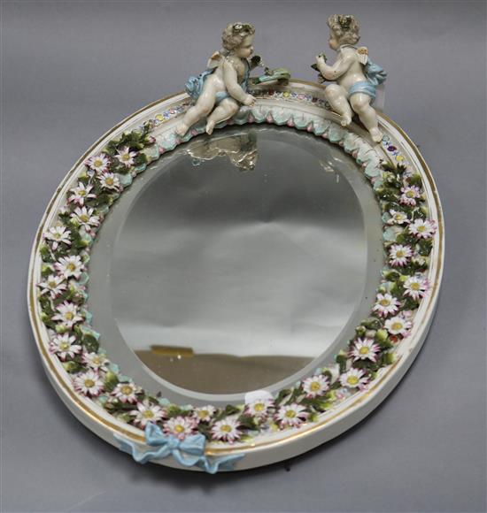 A ceramic floral and putti encrusted wall mirror length 42cm